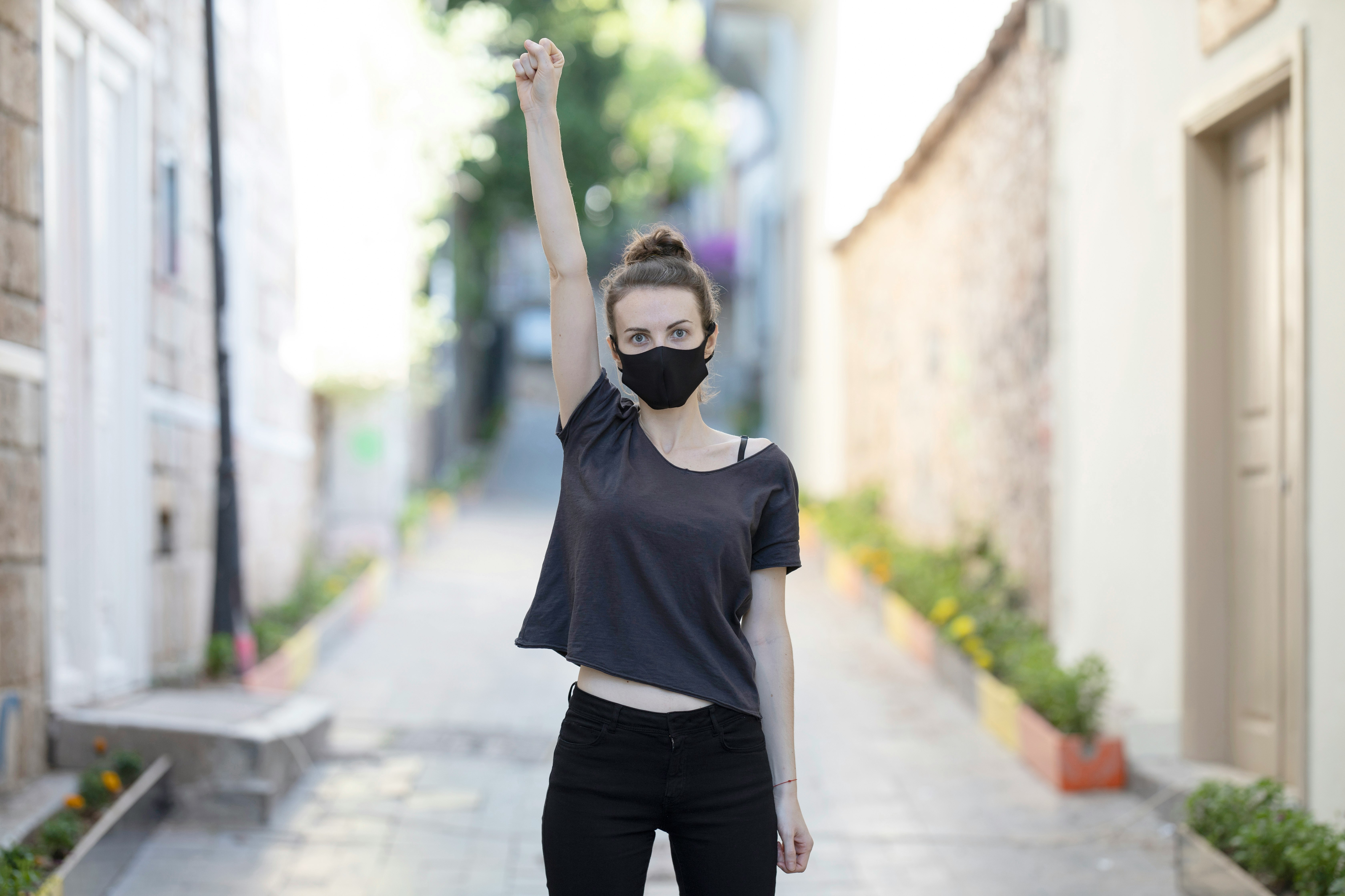 woman in black crew neck t-shirt and black pants standing on sidewalk during daytime